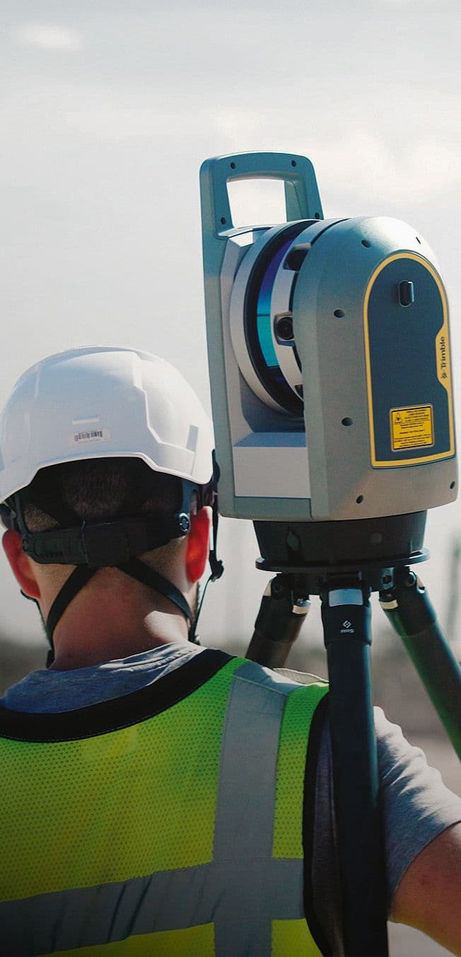 Man met veiligheidskleding en een trimble product op de schouder