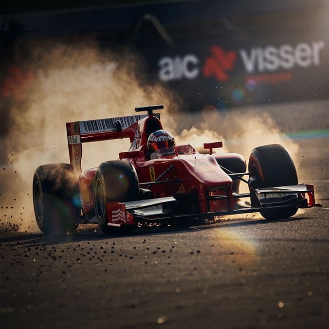 Rode Formule 1-auto racen op een circuit, omgeven door opspattend grind en stof, voor een reclamebord van AIC Visser.